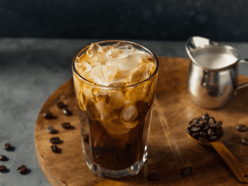 Clotted Cream Coffee on wooden board with coffee beans on