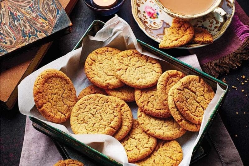 Cornish fairings on a tray with a cup of tea alongside